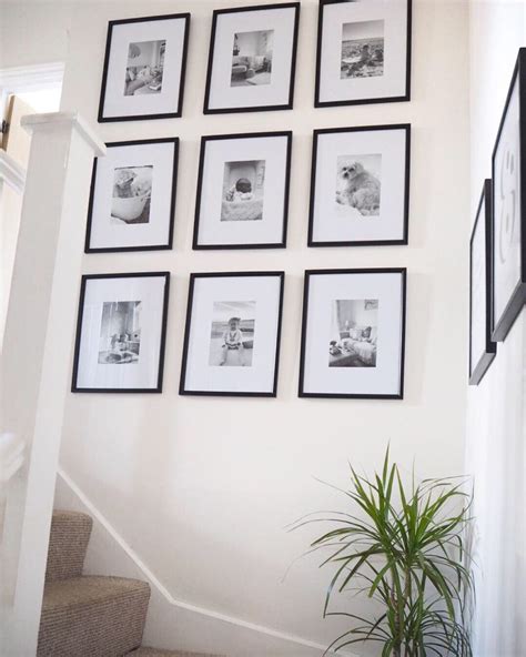 Diy Gallery Wall Layout Featuring Nine Large Prints On A Stairs Wall