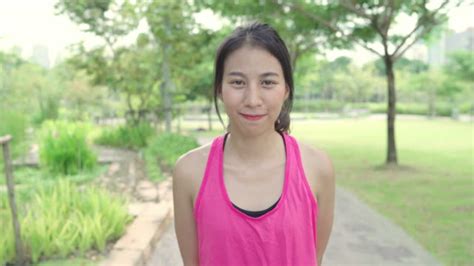 gesunde schöne junge asiatische läufer frau glücklich lächelnd und betreuen kamera läuft auf