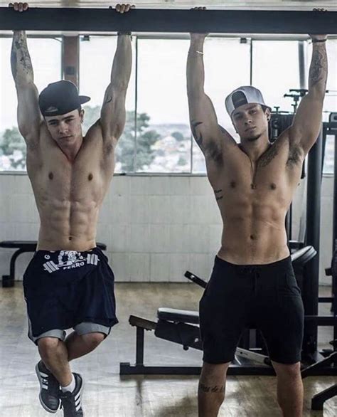 Two Men Doing Pull Ups In A Gym