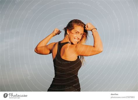 Young Girl Showing Strong Biceps After Outdoors Fitness Workout