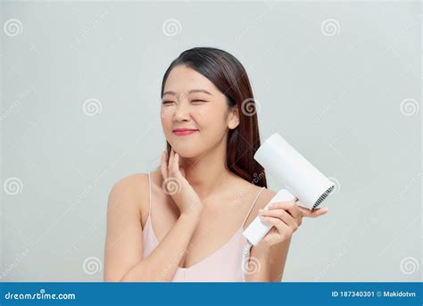 Attractive Cheerful Asian Girl Blows Dry Her Hair With Hairdryer Over White Stock Image Image