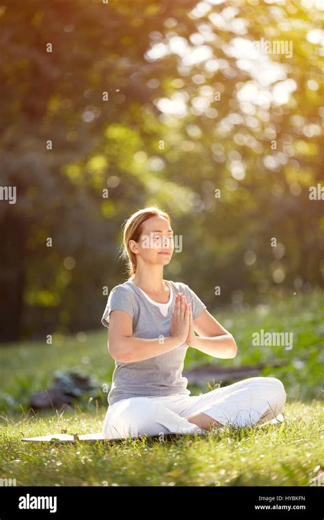 Calm Woman Meditating In Yoga Pose In Green Nature Stock Photo Alamy