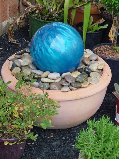 There Is A Blue Ball In The Center Of This Planter With Rocks On It