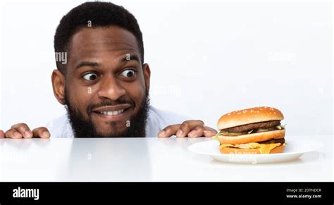 Funny Hungry Black Man Looking At Burger Over White Background Stock Photo Alamy