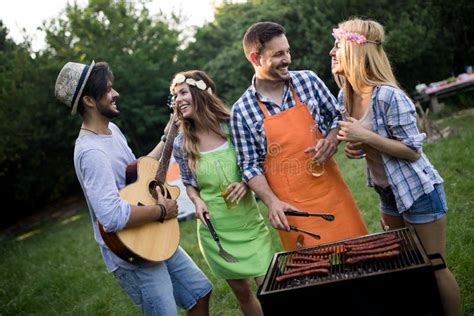 Group Of Happy People Standing Around Grill Chatting Drinking And Eating Stock Image Image