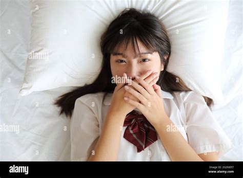 Portrait Japanese School Girl Uniform Sleep And Look At Camera In White Tone Bed Room Stock
