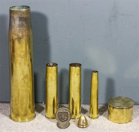 A Large Brass Shell Case 28ins High Together With Four Other Brass