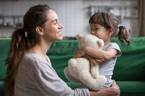 Madre Sonriente Que Abraza A La Hija Linda Que Muestra Amor Y Cuidado