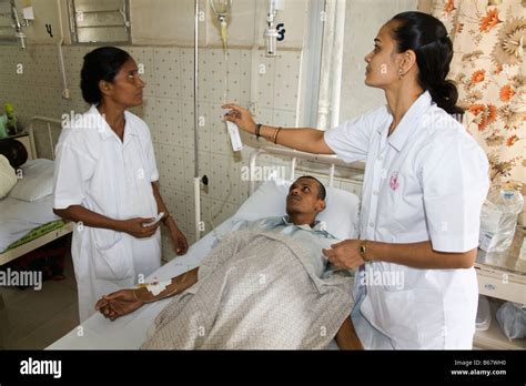 Nurses Treating A Patient With An Intraveinous Drip On A General Ward