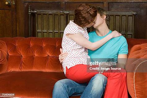 Teen Boy Girl Kissing On The Couch Photos And Premium High Res Pictures
