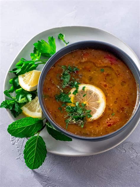 A Bowl Of Soup With Lemon And Parsley