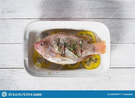 Raw Red Tilapia Fish Cooked With Herbs Spices Paprika And Tomatoes