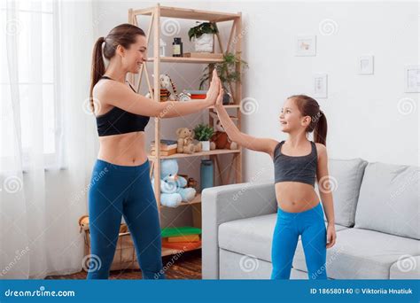 Healthy Lifestyle Mother And Daughter In Sportswear Standing Exercising Showing Biceps Smiling