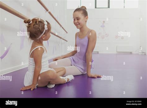 Beautiful Young Ballerina Smiling At Cute Little Girl Wearing Leotard