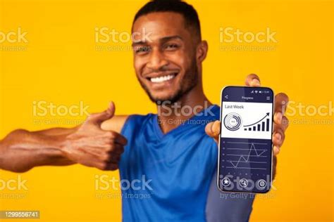 Black Man Demonstrating Phone With Progres Tracker App Yellow