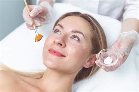 Beautician Applying Facial Mask To The Young Lady Stock Photo Image
