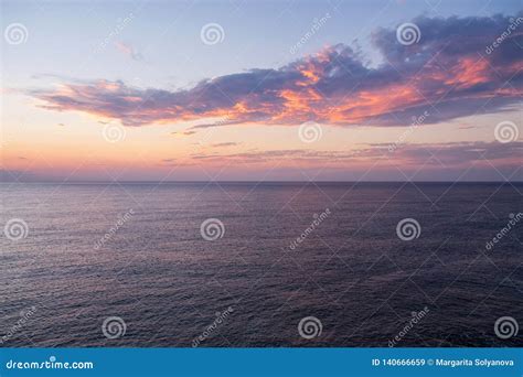 Dramatic Sunset Seascape With Purple Cloud Floating Above The Calm Sea