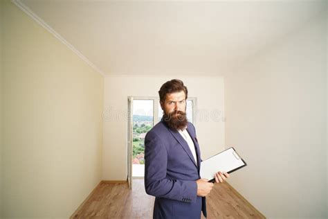 Realtor With Clipboard At New Home Bearded Real Estate Agent With