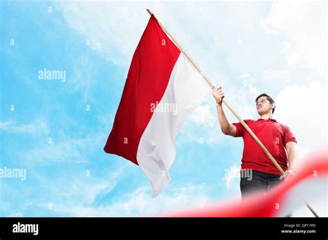 Indonesian Men Celebrate Indonesian Independence Day On 17 August By Holding The Indonesian Flag