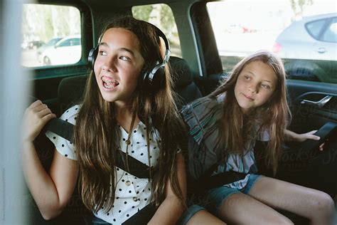 Two Teenage Girls In The Back Seat Of A Car Looking Outside Cheerful