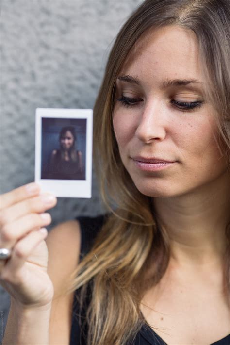 Young Woman Holding Her Polaroid Portrait By Alberto Bogo