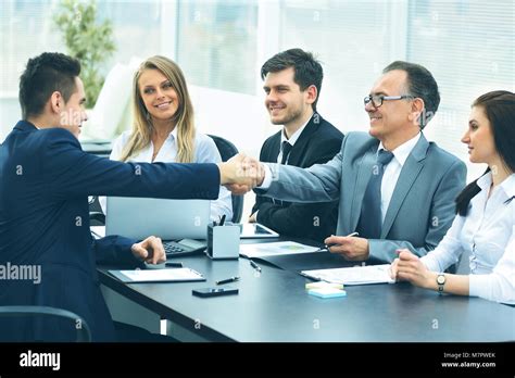 Business Meeting At The Table And Handshake Of Business Partners Stock