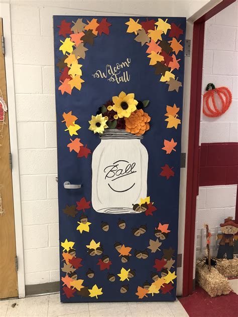 A Door Decorated With Fall Leaves Flowers And A Mason Jar That Says