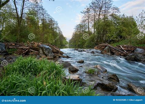 Long Exposure From A Floating Idyllic River With Stones And Grass In