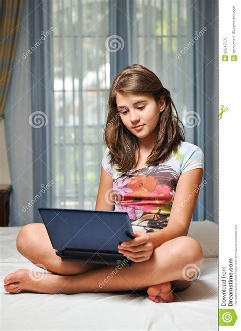 Young Teen Girl Laying On Her Bed With Notebook Stock