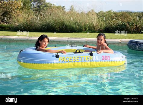 kinderschwimmbecken zwei junge mädchen die in einem aufblasbaren boot in einem schwimmbad