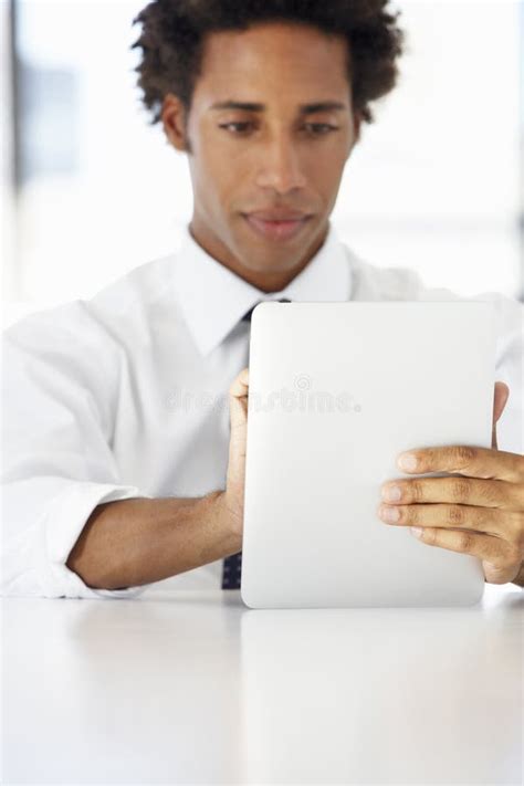Businessman Sitting At Desk In Office Using Digital Tablet Stock Image