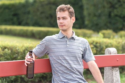 Young Man Sitting On Bench With A Bottle Of Beer Stock Image Image Of