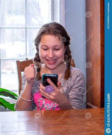 Teen Cheers On Her Friends As She Watches Her Cell Phone Stock Image