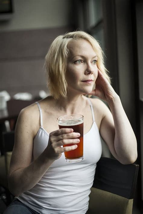 blondynki kobieta z pięknymi niebieskimi oczami pije czara piwo obraz stock obraz złożonej z
