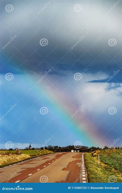 Beautiful Colorful Rainbow At The End Of Asphalt Road Perspective View