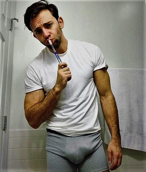 A Man Brushing His Teeth In The Bathroom