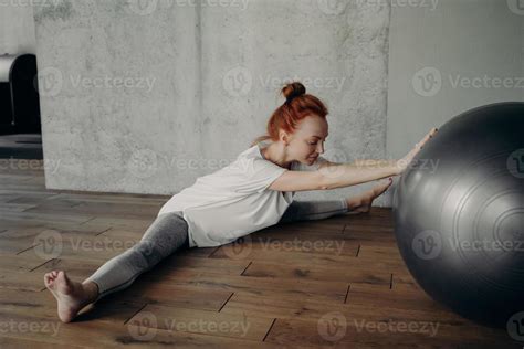 Jeune Femme Flexible En Position Fendue Qui Sétend Des Jambes Avec Un