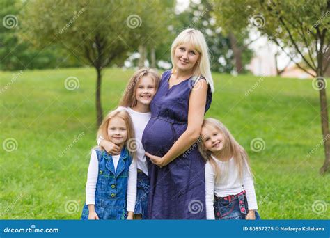 Madre Embarazada De Los Jóvenes Con Su Familia En Un Parque Imagen De