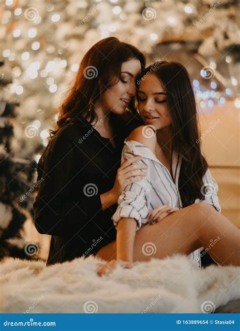 Lesbian Couple Sits Against Background Of Christmas Decorations Stock Photo Image Of