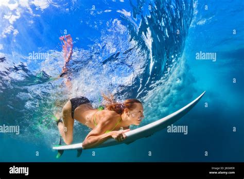 Active Girl In Bikini In Action Surfer Woman With Surf Board Dive Underwater Under Breaking Big