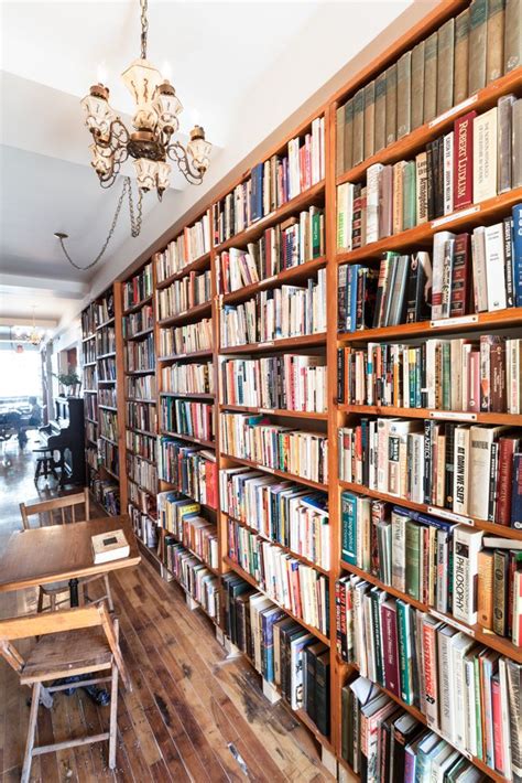 A Large Bookcase Filled With Lots Of Books Next To A Dining Room Table