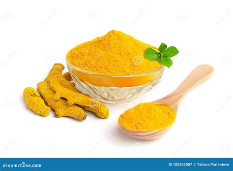 Turmeric Powder In Glass Bowl With Green Leaves Dry Roots And Wooden
