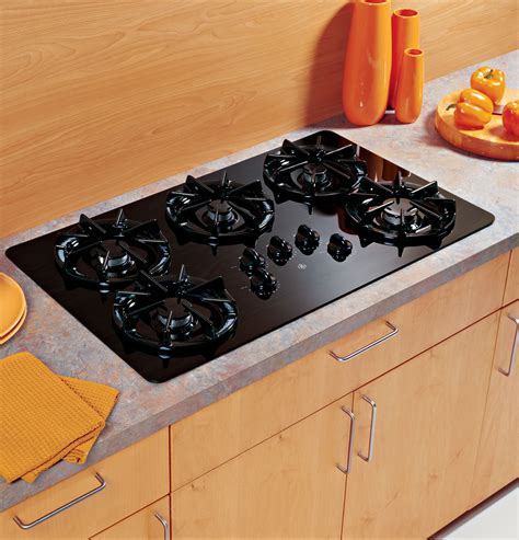 Gas cooktops can put out a lot of heat, so when planning an installation, it's important to make sure you'll have at least minimum clearances all around the unit to avoid damage to cabinets and wall finishes. GE® 36" Built-In Gas Cooktop | JGP637BEJBB | GE Appliances
