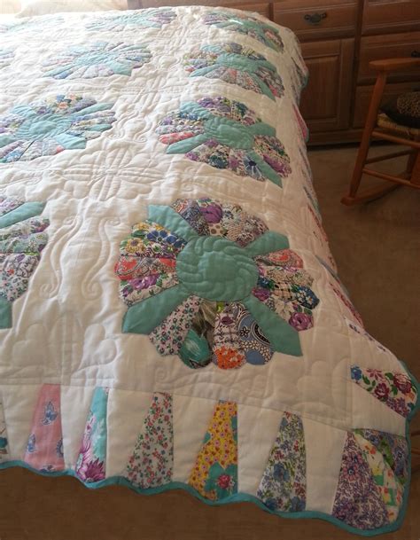 A Quilted Bedspread With Flowers On It