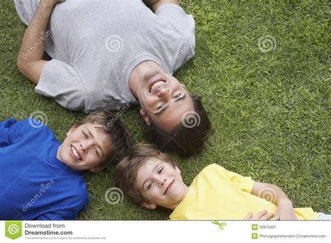 Happy Father And Two Sons Lying On Grass Stock Image Image Of