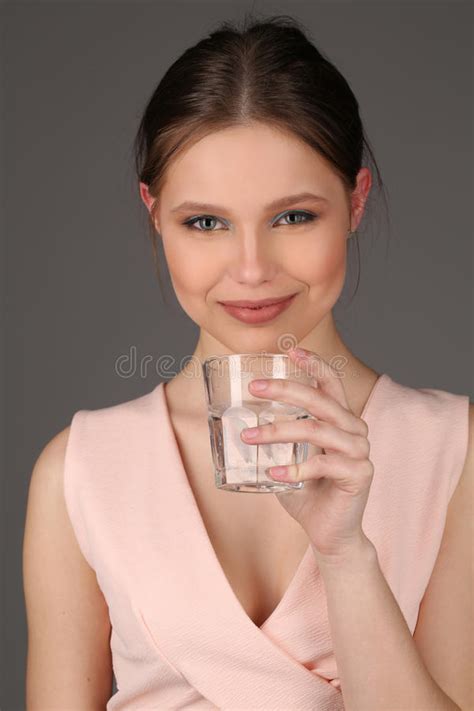 Model With Makeup Drinking Water Close Up Gray Background Stock Photo