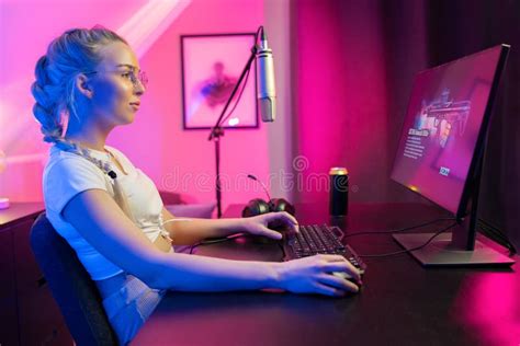 Focused Beautiful Blonde Gamer Girl Playing Online Video Game On Her Personal Computer Stock