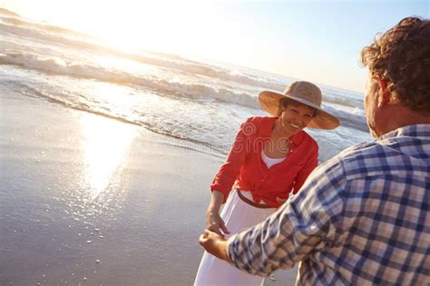 sharing a perfect day together a mature couple enjoying a late afternoon walk on the beach