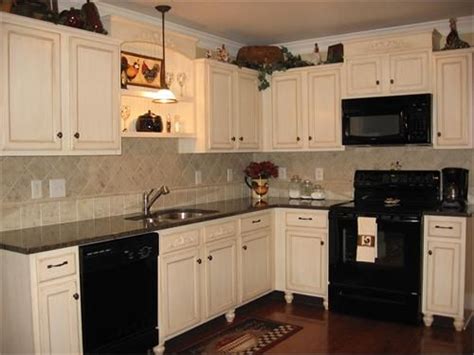 If you are considering white to reface your existing kitchen cabinets, or for new cabinetry altogether, you are not alone in your color choice. White cabinets with black appliances | Black appliances ...