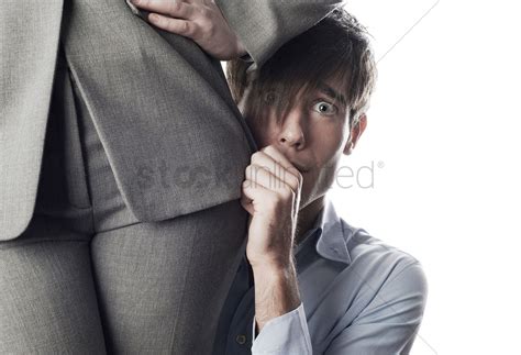Businessman hiding behind businesswoman Stock Photo ...